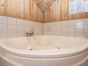 a bath tub in a bathroom with wooden walls at 10 person holiday home in Skjern in Lem