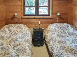 2 aparte bedden in een slaapkamer met houten wanden bij Holiday home Hadsund CVIII in Hadsund