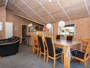 a dining room with a wooden table and chairs at 8 person holiday home in Oksbøl-By Traum in Oksbøl