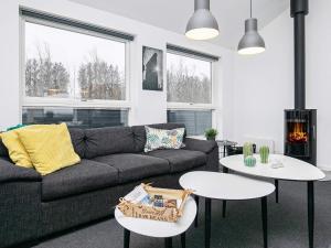 uma sala de estar com um sofá e duas mesas em 6 person holiday home in L kken em Lokken