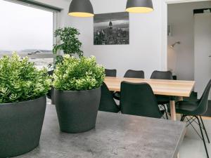 uma sala de jantar com uma mesa e dois vasos de plantas em 6 person holiday home in L kken em Lokken