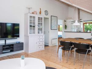 cocina y comedor con mesa y TV en 8 person holiday home in Ebeltoft, en Ebeltoft