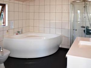El baño incluye bañera blanca y aseo. en 8 person holiday home in Ebeltoft, en Ebeltoft