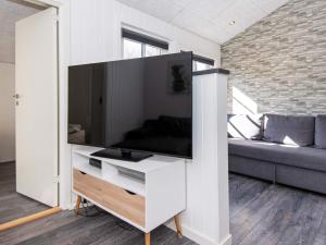 un salon avec une grande télévision à écran plat sur une armoire dans l'établissement 8 person holiday home in Ringk bing, à Ringkøbing