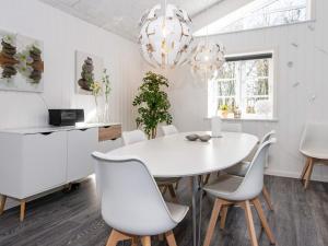- une salle à manger blanche avec une table et des chaises blanches dans l'établissement 8 person holiday home in Ringk bing, à Ringkøbing
