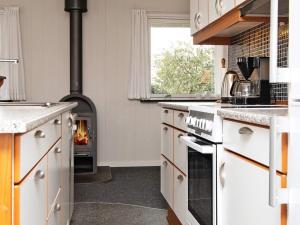 a kitchen with a stove with a fire in it at 6 person holiday home in B rkop in Børkop