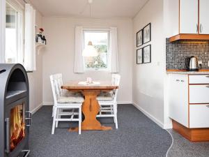 a kitchen with a wooden table and two chairs at 6 person holiday home in B rkop in Børkop