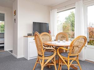 a dining room with a table and chairs and a tv at 6 person holiday home in B rkop in Børkop