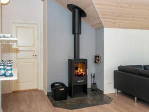 a black fireplace in a living room with a couch at 8 person holiday home in Glesborg in Glesborg