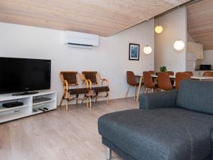 a living room with a couch and a table with chairs at 8 person holiday home in Glesborg in Glesborg