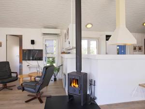 a fireplace in a living room with a stove at 12 person holiday home in V ggerl se in Marielyst