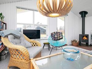 ein Wohnzimmer mit einem Glastisch und einem Kronleuchter in der Unterkunft 5 person holiday home in Hj rring in Vester Vidstrup