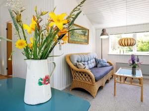 ein Wohnzimmer mit einer Blumenvase auf dem Tisch in der Unterkunft 5 person holiday home in Hj rring in Vester Vidstrup
