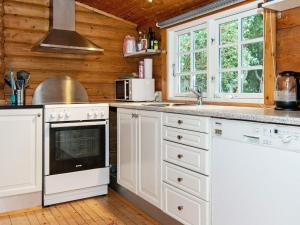 a kitchen with white appliances and wooden walls at Holiday home Knebel V in Knebel