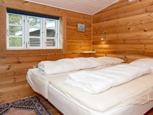 a bedroom with two beds in a log cabin at Holiday home Knebel V in Knebel
