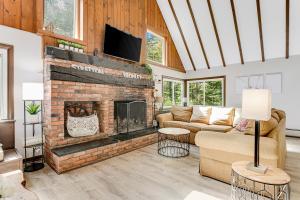 a living room with a brick fireplace with a tv at Rocky Red in Bromley Village