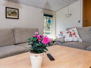 ein Wohnzimmer mit einem Sofa und einer Pflanze auf einem Couchtisch in der Unterkunft 6 person holiday home in Glesborg in Glesborg
