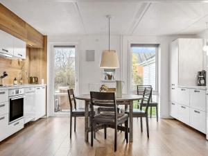 uma cozinha com uma mesa de jantar e cadeiras em Apartment Rømø XXXI em Sønderby