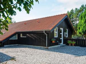 a black shed with a red roof at 6 person holiday home in Ulfborg in Ulfborg