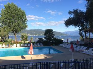 una piscina con sedie e vista sull'acqua di Dkamping Village - International Camping Ispra a Ispra