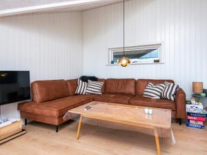 ein Wohnzimmer mit einem braunen Sofa und einem Couchtisch in der Unterkunft Holiday home Sydals XLI in Mommark