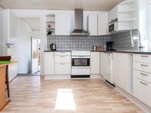cocina con electrodomésticos blancos y suelo de madera en 4 person holiday home in Toftlund, en Toftlund