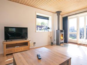a living room with a flat screen tv and a fireplace at Holiday home Oksbøl LXIX in Oksbøl