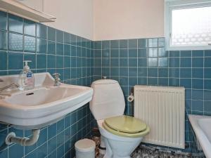 a blue tiled bathroom with a toilet and a sink at 8 person holiday home in Hasle in Hasle +9 photos