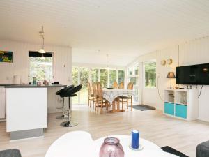 a kitchen and living room with a table and chairs at 5 person holiday home in H jslev in Højslev