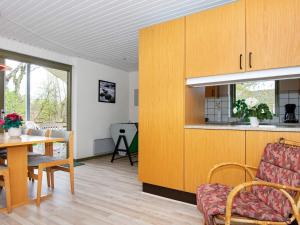 a living room with a table and a kitchen at Holiday home Glesborg XIX in Glesborg