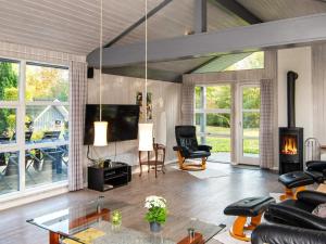 a living room with a fireplace and a tv at Four-Bedroom Holiday home in Glesborg 2 in Glesborg
