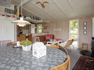 a kitchen and living room with a table and chairs at 4 person holiday home in H jslev in Højslev
