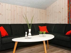 uma sala de estar com um sofá preto e uma mesa branca em 6 person holiday home in B rkop em Egeskov