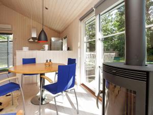 a kitchen and dining room with a table and blue chairs at 5 person holiday home in V ggerl se in Marielyst