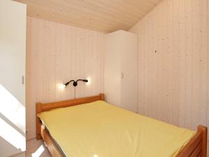 a small bedroom with a yellow bed in it at 5 person holiday home in V ggerl se in Marielyst