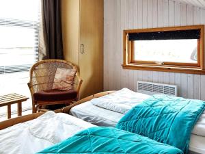 um quarto com 2 camas, uma cadeira e uma janela em Three-Bedroom Holiday home in Ringkøbing 1 em Ringkøbing