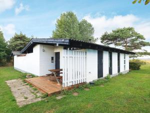 un edificio blanco con una mesa de picnic delante de él en 4 person holiday home in Tranek r, en Stoense