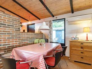 comedor con mesa, sillas y pared de ladrillo en 4 person holiday home in Tranek r, en Stoense