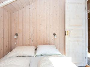 Cama en habitación con pared de madera en Holiday home Ansager XXXIX en Ansager