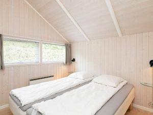 オテルプにあるThree-Bedroom Holiday home in Otterup 1のベッドルーム1室(ベッド2台、窓付)