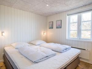 ein Schlafzimmer mit einem Bett mit zwei Kissen darauf in der Unterkunft Holiday home Henne CXVIII in Henne Strand