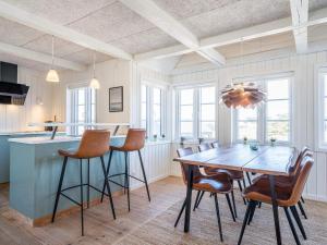 eine Küche und ein Esszimmer mit einem Holztisch und Stühlen in der Unterkunft Holiday home Henne CXVIII in Henne Strand