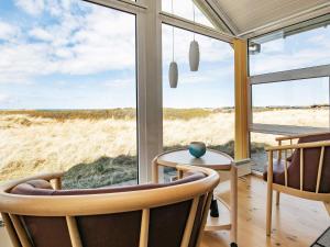 um quarto com duas cadeiras, uma mesa e uma janela em 8 person holiday home in Hj rring em Hjørring
