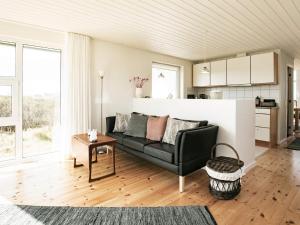 - un salon avec un canapé et une table dans l'établissement 8 person holiday home in Hj rring, à Hjørring