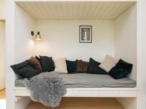 a living room with a couch with pillows at Holiday home Strøby IX in Strøby
