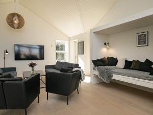 a living room with a couch and a bed and chairs at Holiday home Strøby IX in Strøby