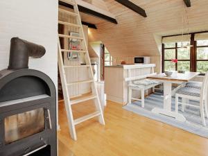 Ulfborgにある6 person holiday home in Ulfborgの暖炉付きの部屋、テーブル付きのキッチンが備わる客室です。