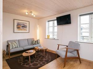 a living room with a couch and a tv at Holiday home Læsø XLI in Læsø