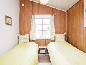 2 Betten in einem kleinen Zimmer mit Fenster in der Unterkunft Holiday home Brenderup Fyn IX in Bro