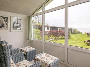 ein Wohnzimmer mit 2 Stühlen und einem großen Fenster in der Unterkunft Holiday home Brenderup Fyn IX in Bro